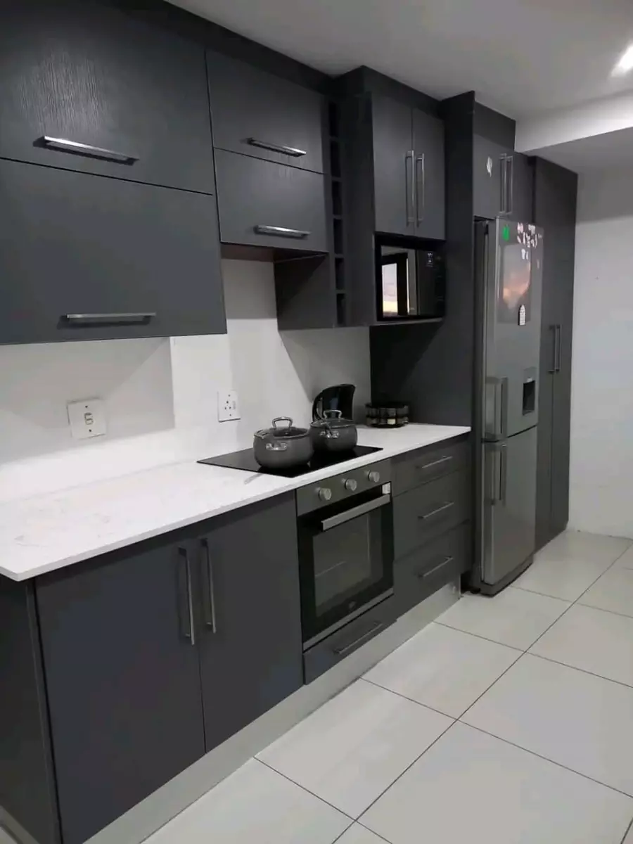 Modern kitchen with dark grey cabinets and white countertops